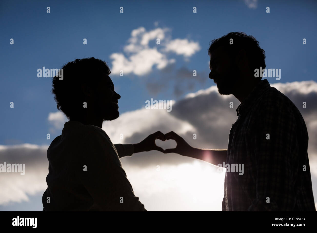 Homosexual couple making hearth with hands Stock Photo