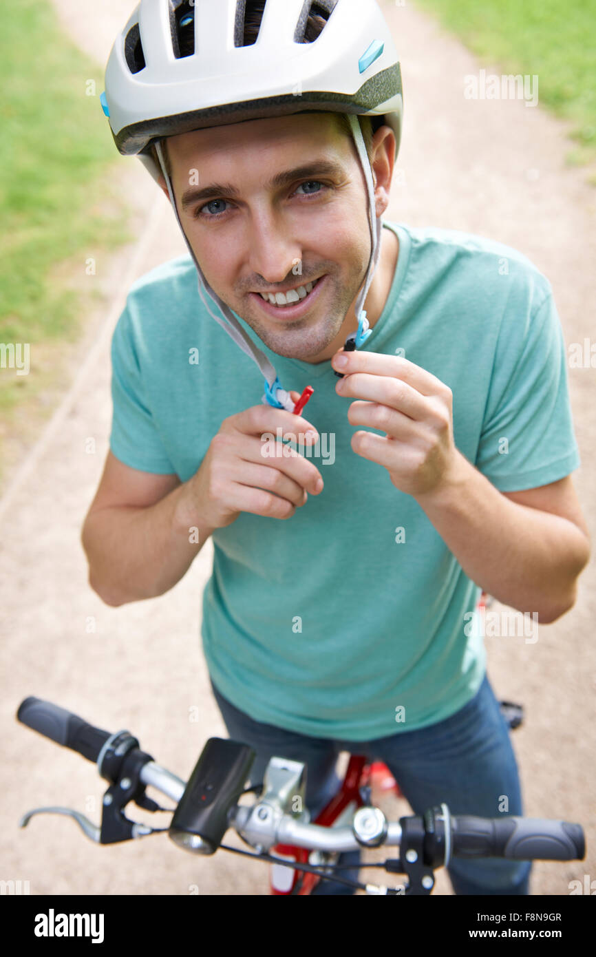 Man Fastening Strap Of Cycle Helmet 