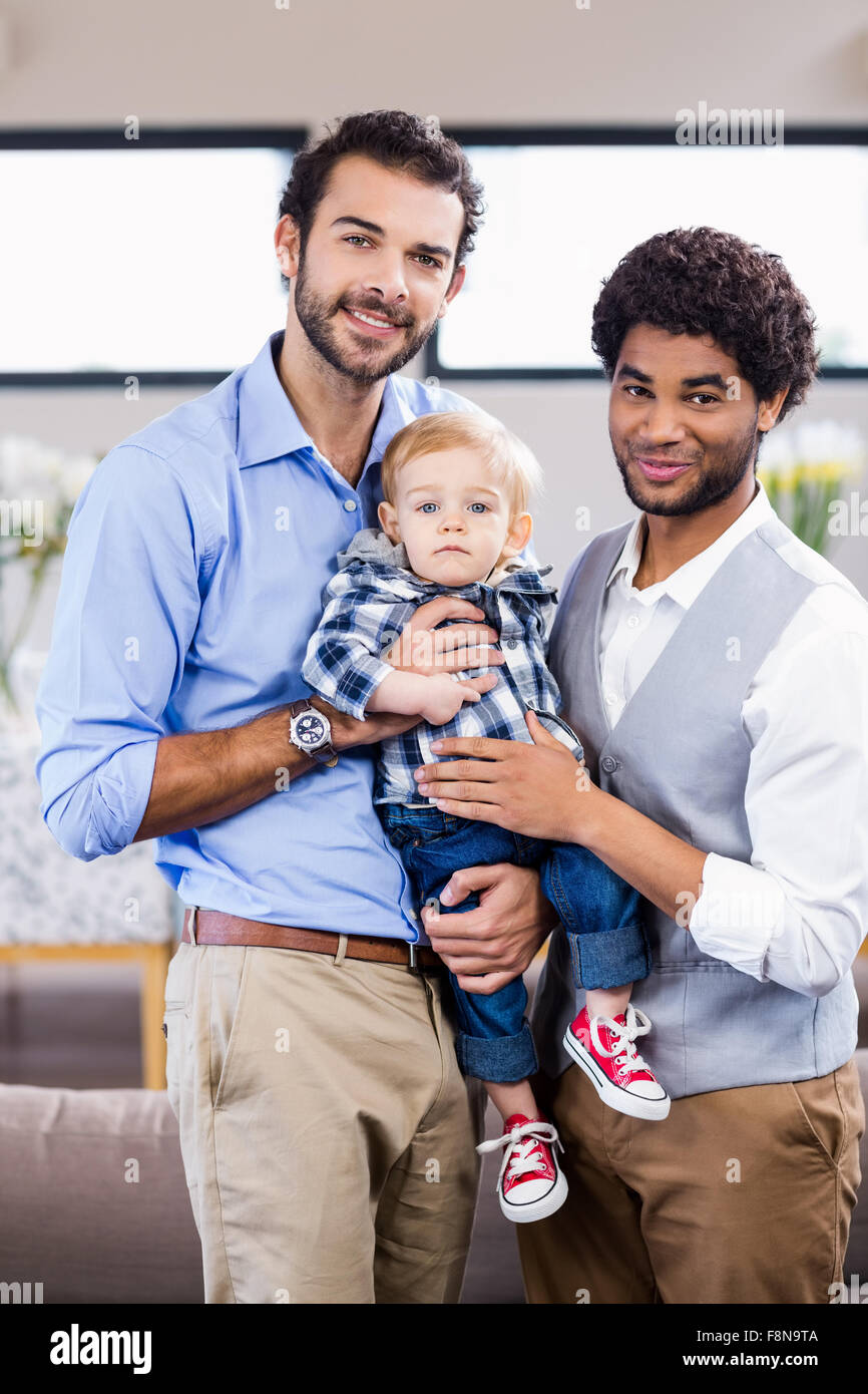 Happy gay couple with child posing for camera Stock Photo