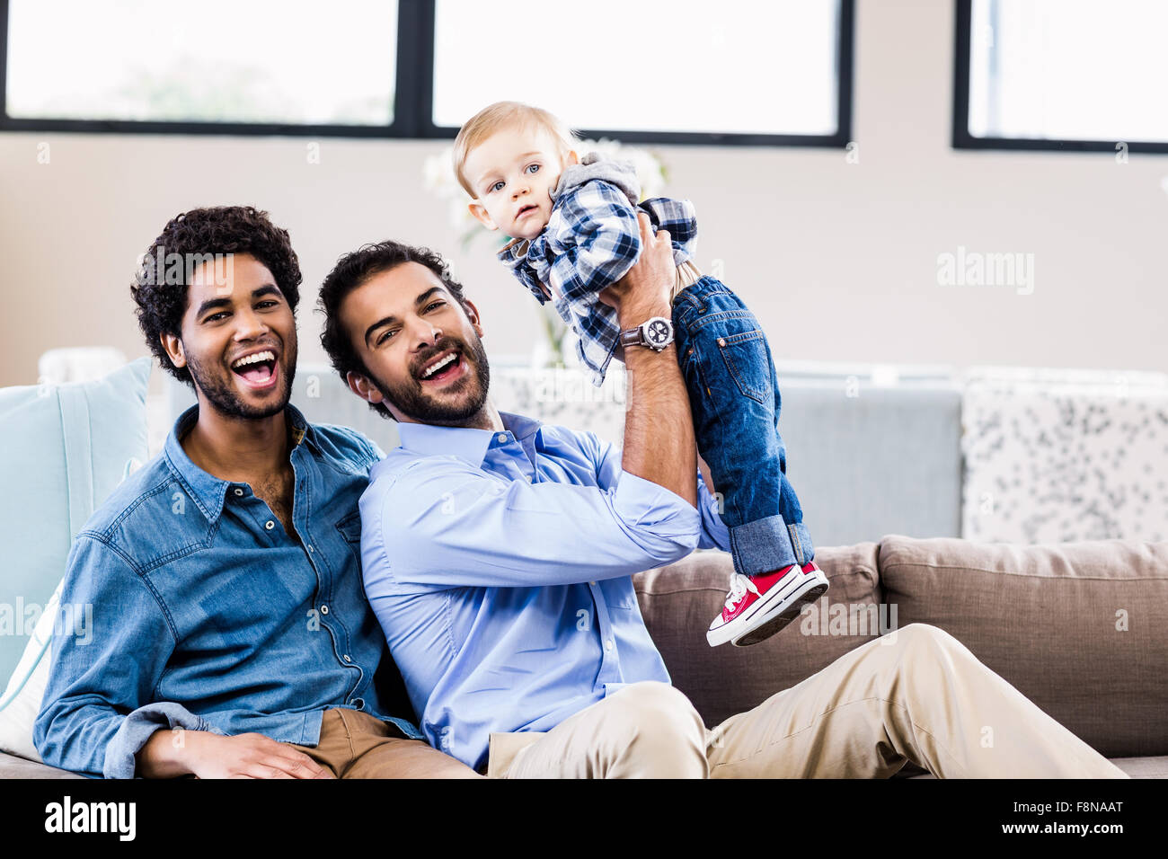 Happy gay couple playing with child Stock Photo