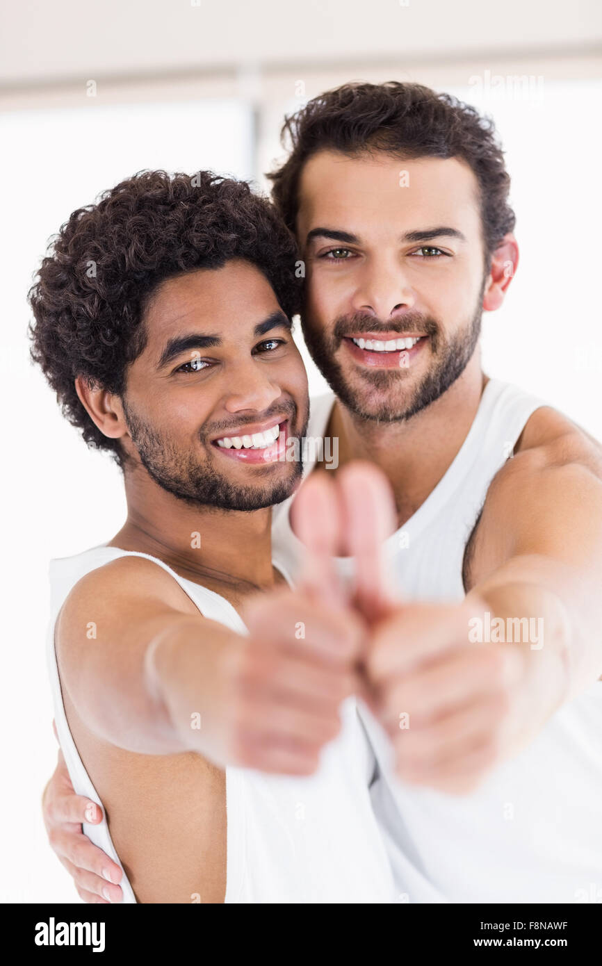 Smiling gay couple showing thmbs up Stock Photo