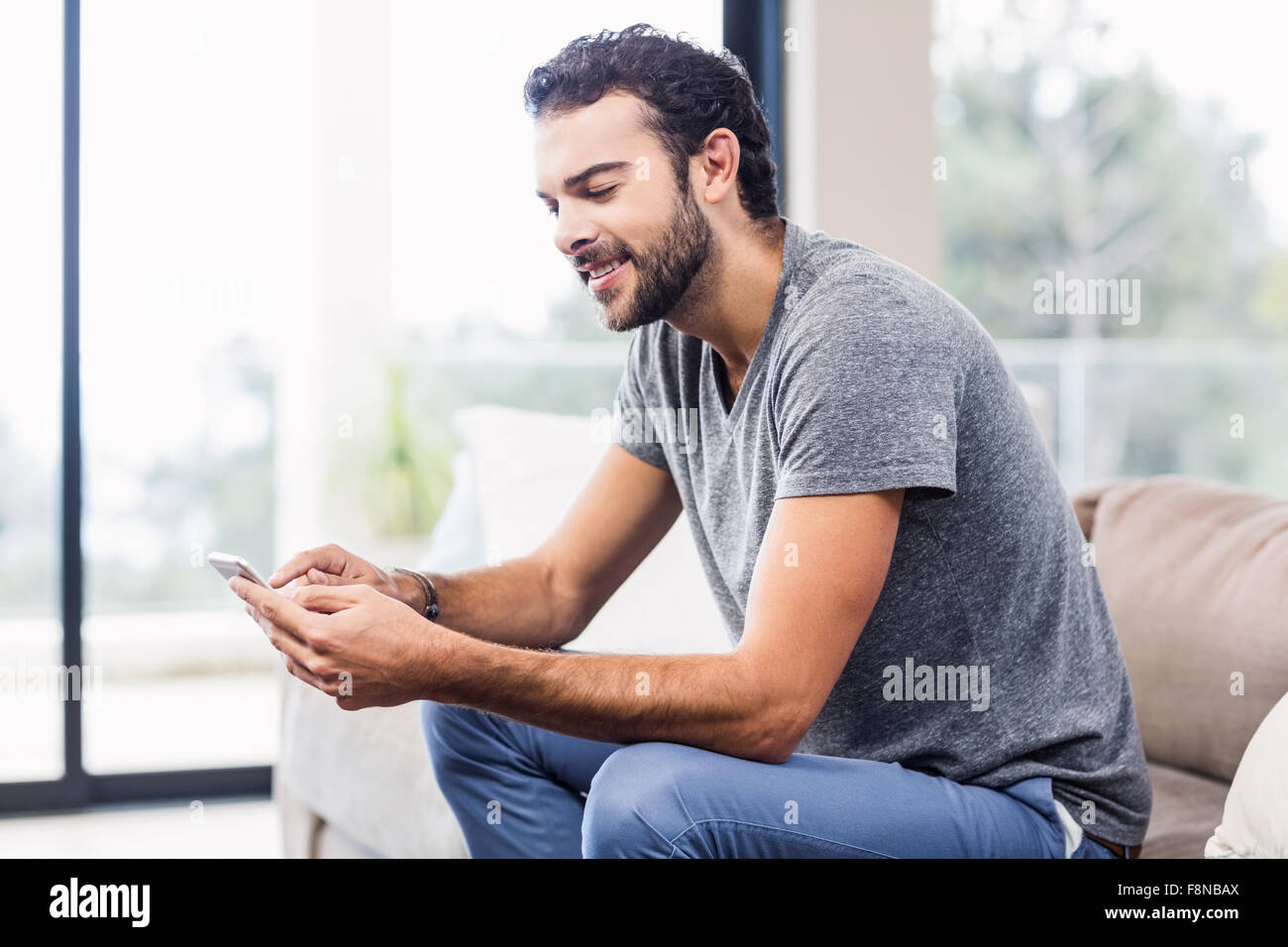 Handsome smiling man using smartphone Stock Photo - Alamy