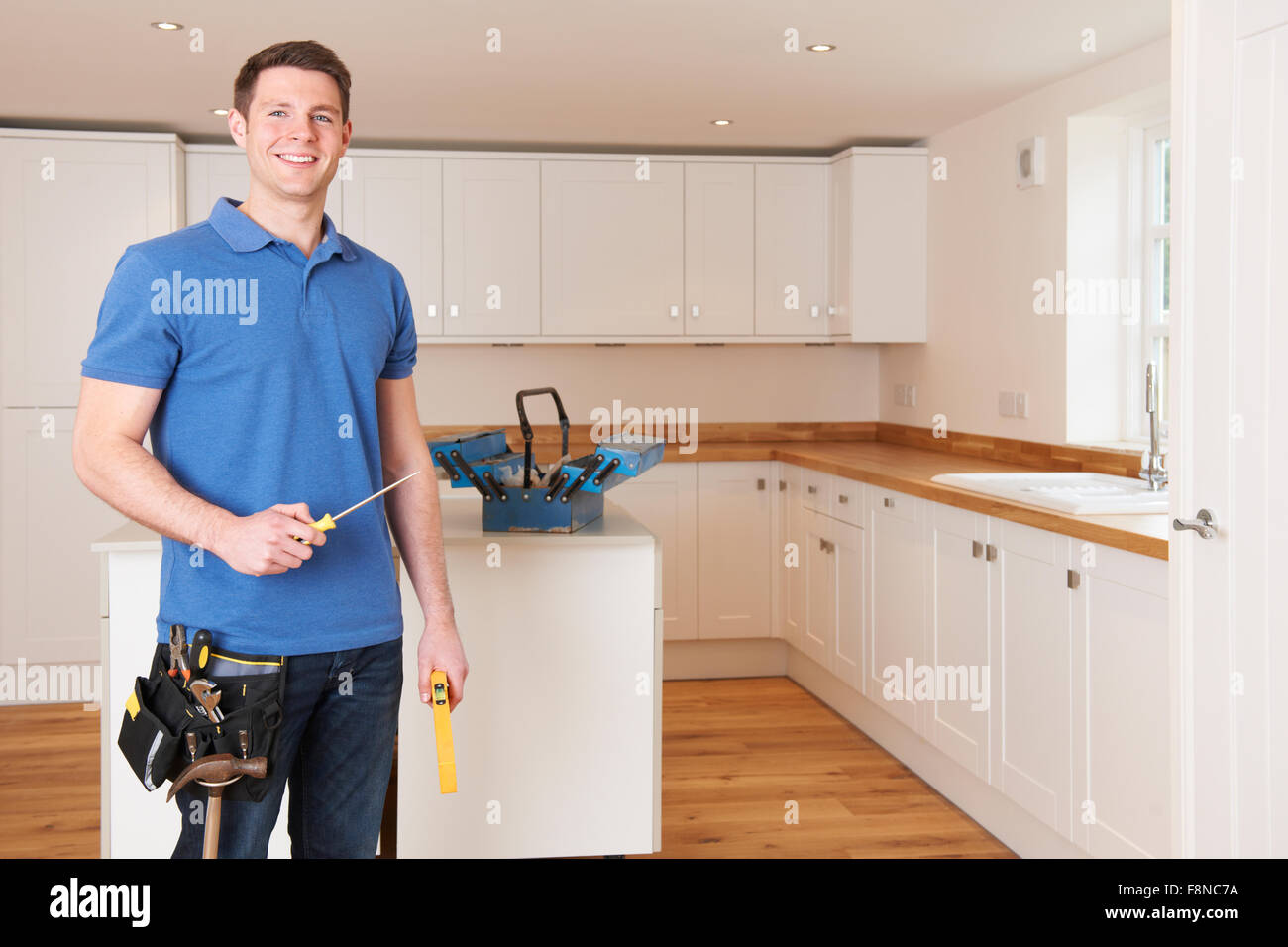 Workman Installing Beautiful Fitted Kitchen Stock Photo