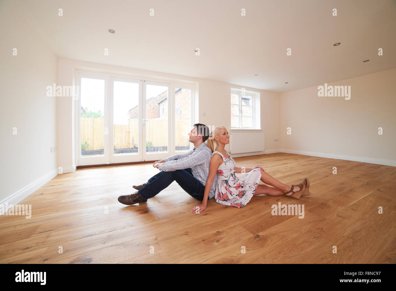 Young Couple Sitting In Empty Room Of Dream House Stock Photo Alamy