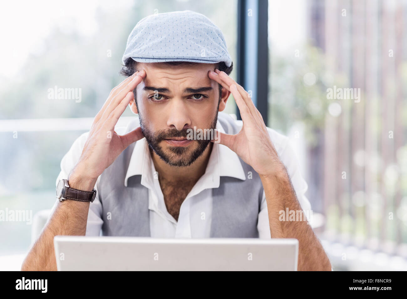 Worried man with hands on his face looking at the camera Stock Photo