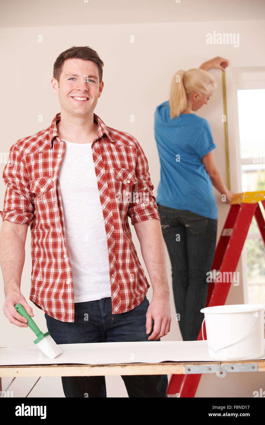 Young Couple Decorating Home Together Stock Photo