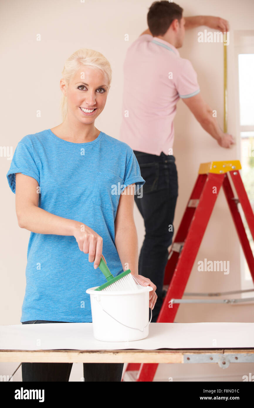 Young Couple Decorating Home Together Stock Photo