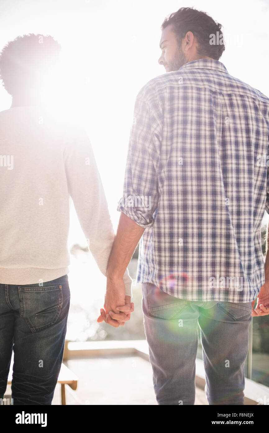 happy gay couple holding hands together Stock Photo
