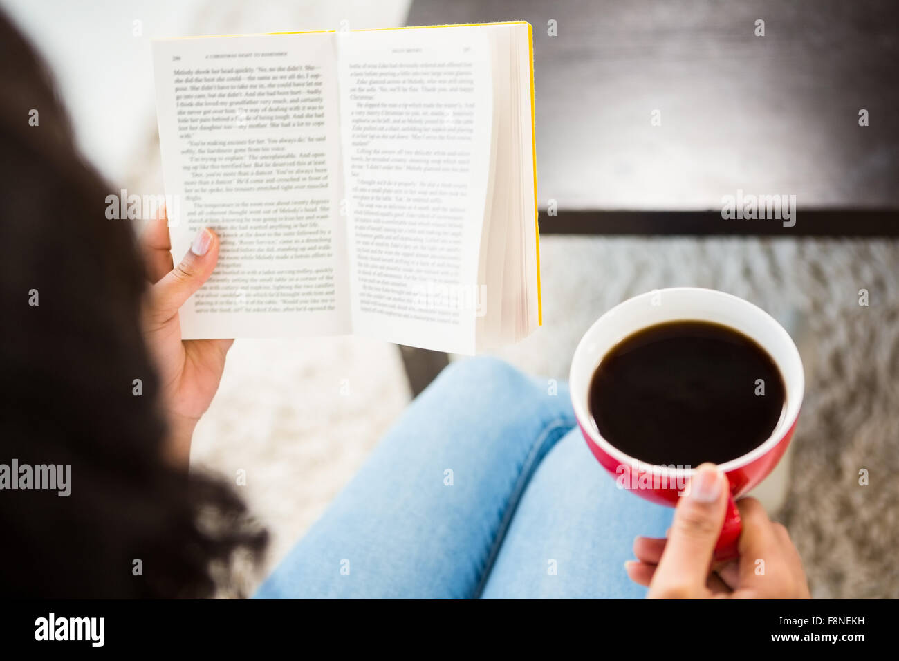 Cropped image of woman with coffee reading book Stock Photo