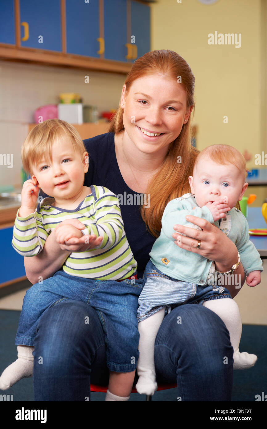 Happy Mother With Two Young Children At Baby Group Stock Photo