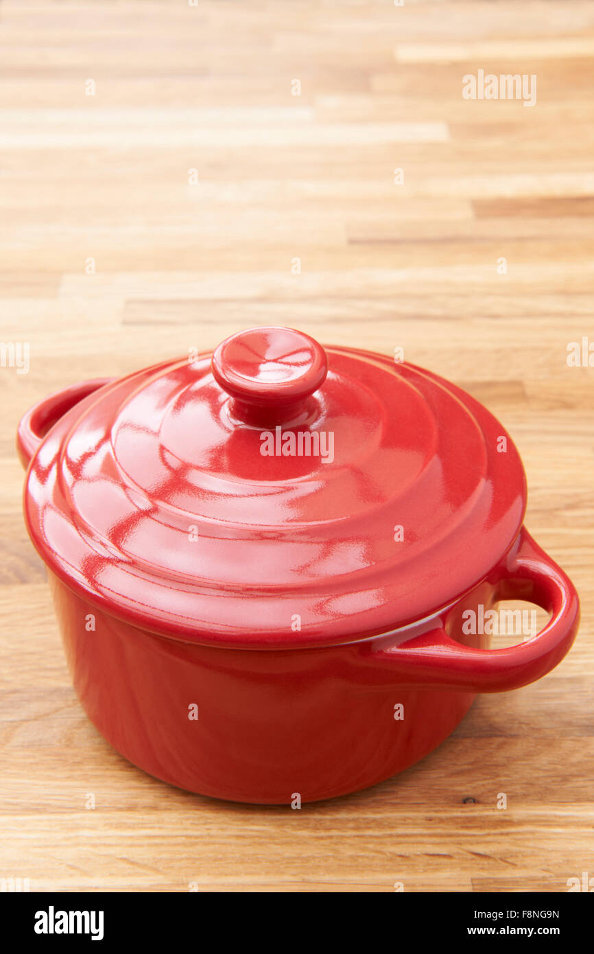 Red Casserole Dish On Wooden Surface Stock Photo