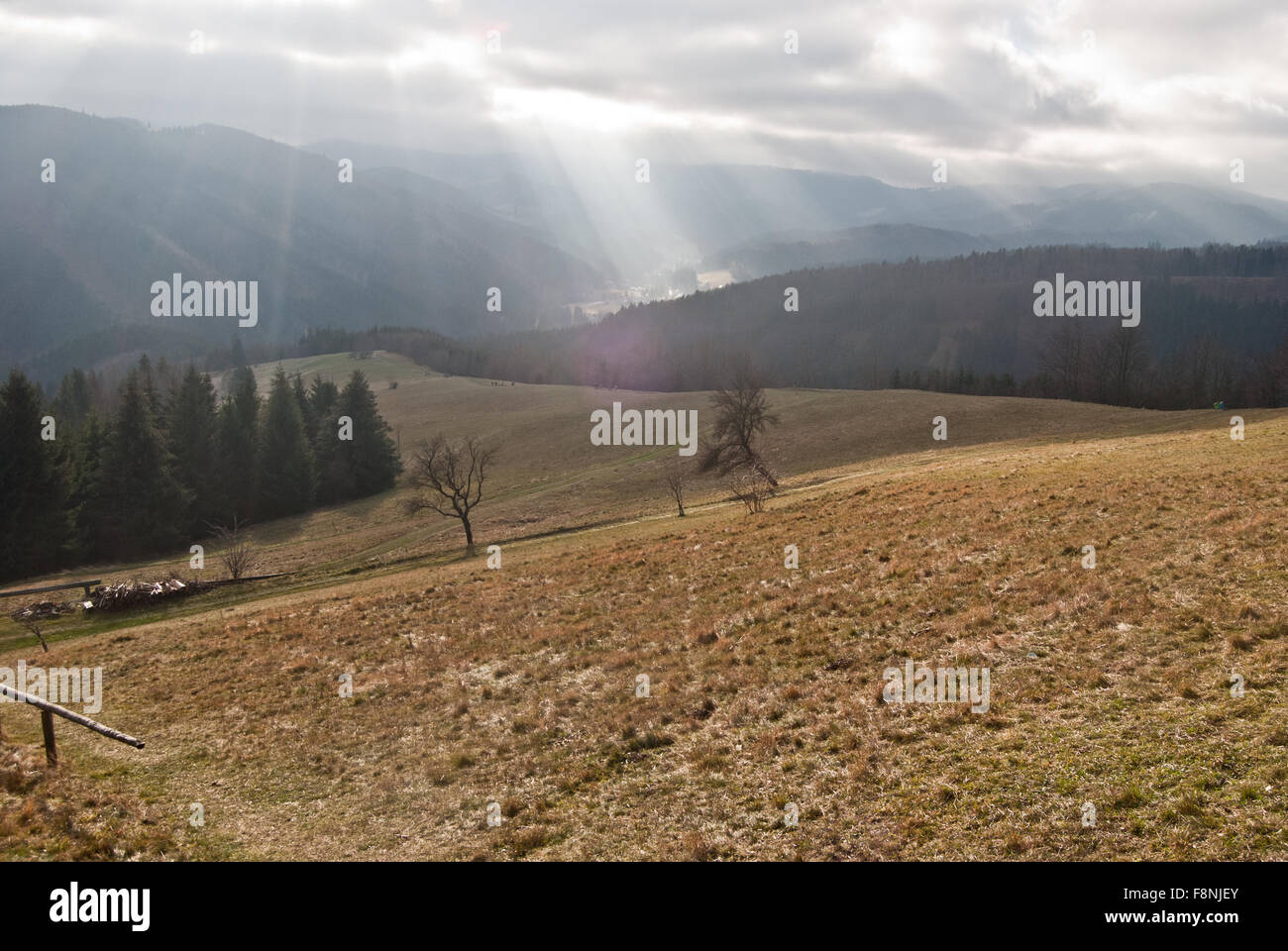 late autumn meadow with hills on the background and clouds with sunlights near Chata Kamenity in Moravskoslezske Beskydy Stock Photo
