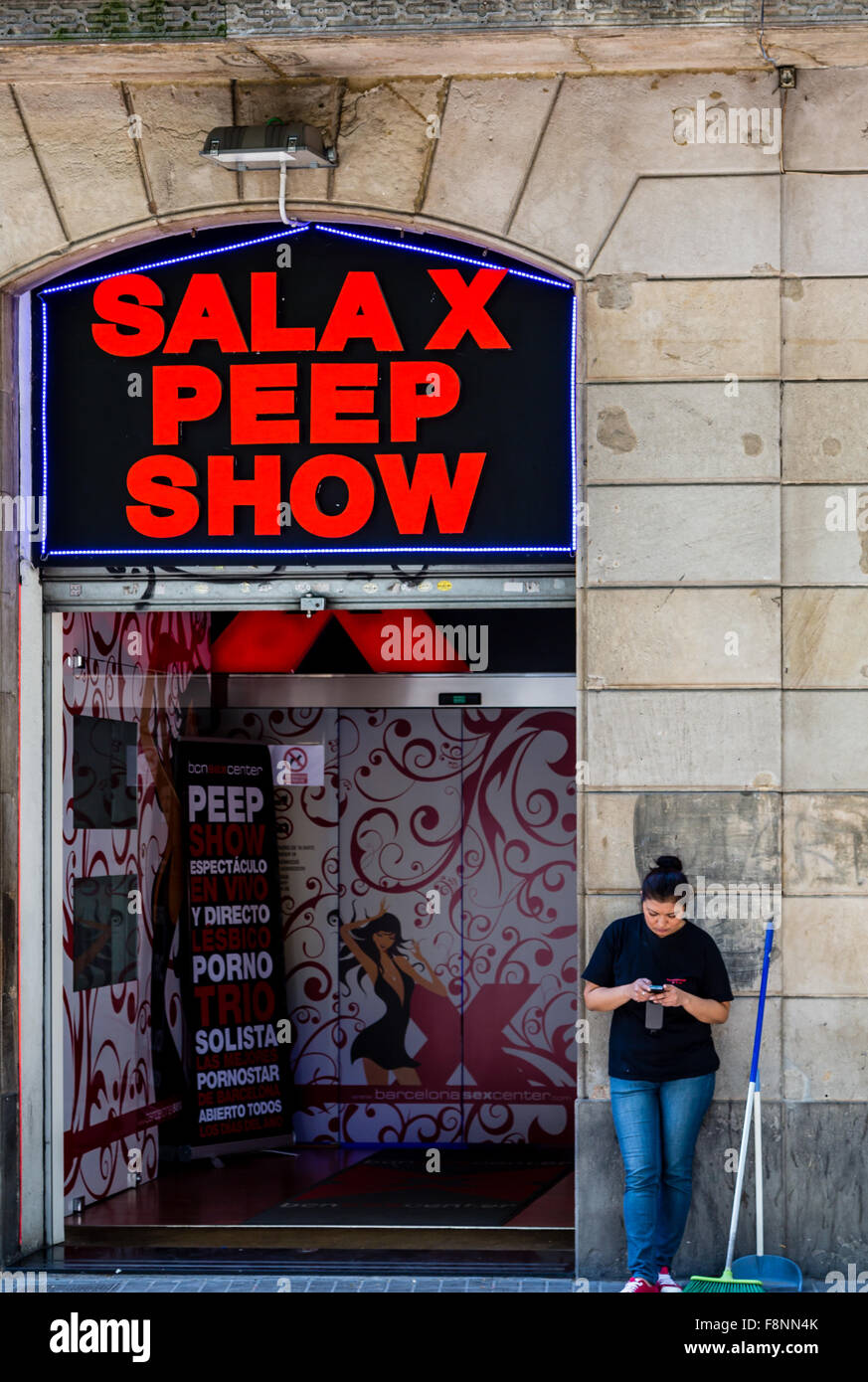 Cleaning Woman Texting Outside Peep Show Stock Photo