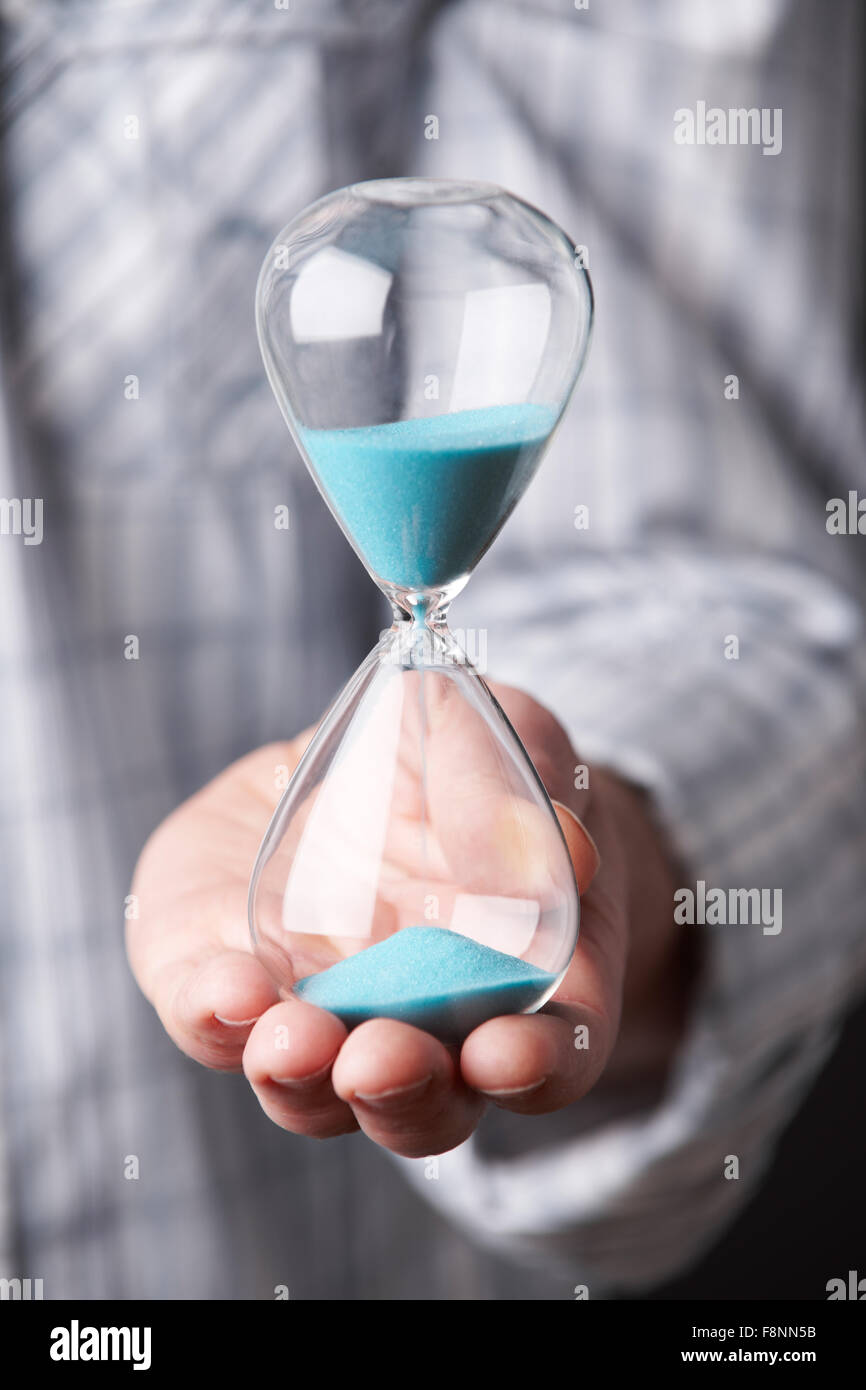 Male Hand Holding Hourglass Stock Photo