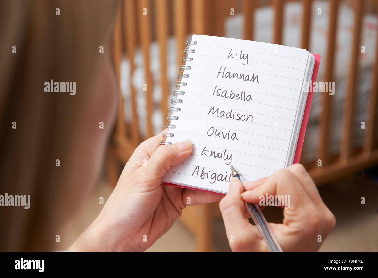 Woman Writing Names For Baby Girl In Nursery Stock Photo