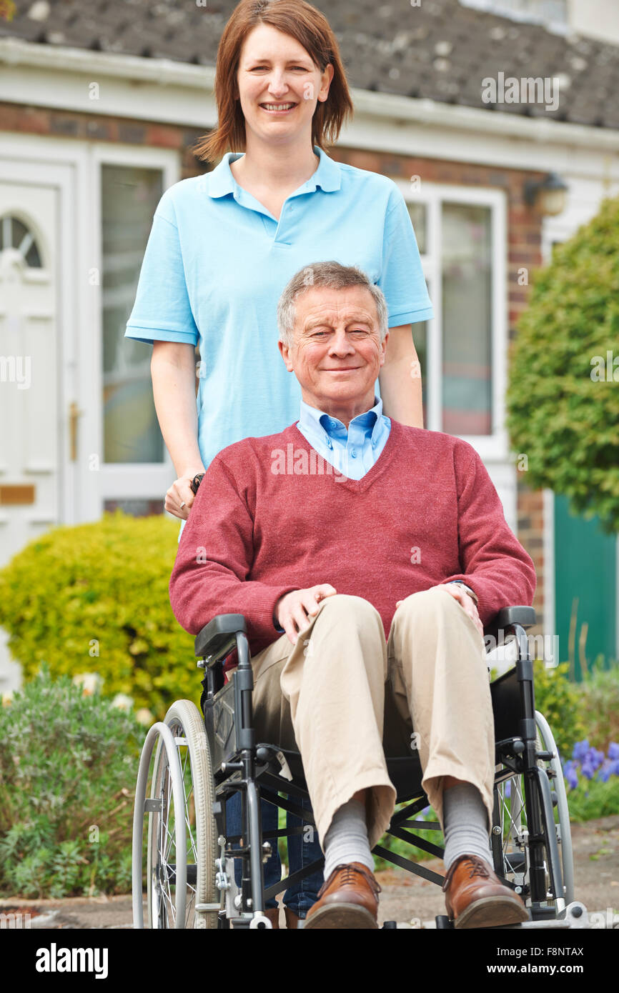 Carer With Senior Man In Wheelchair Stock Photo