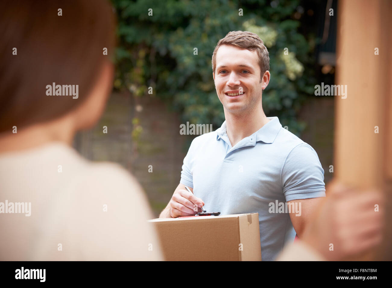 Courier Delivering Package To Domestic House Stock Photo