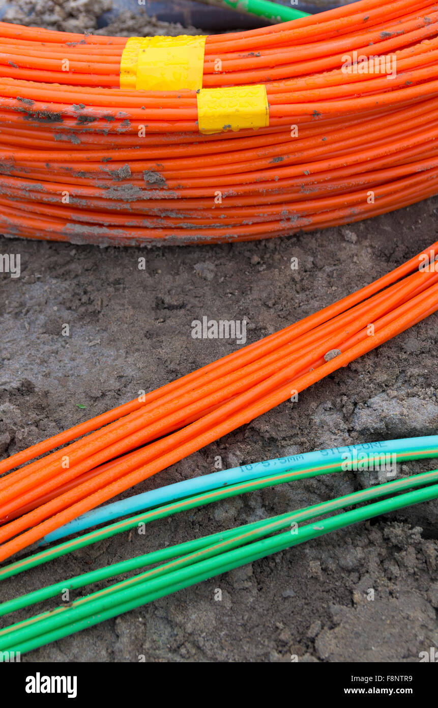 orange and green fiber optic cables on a construction site Stock Photo