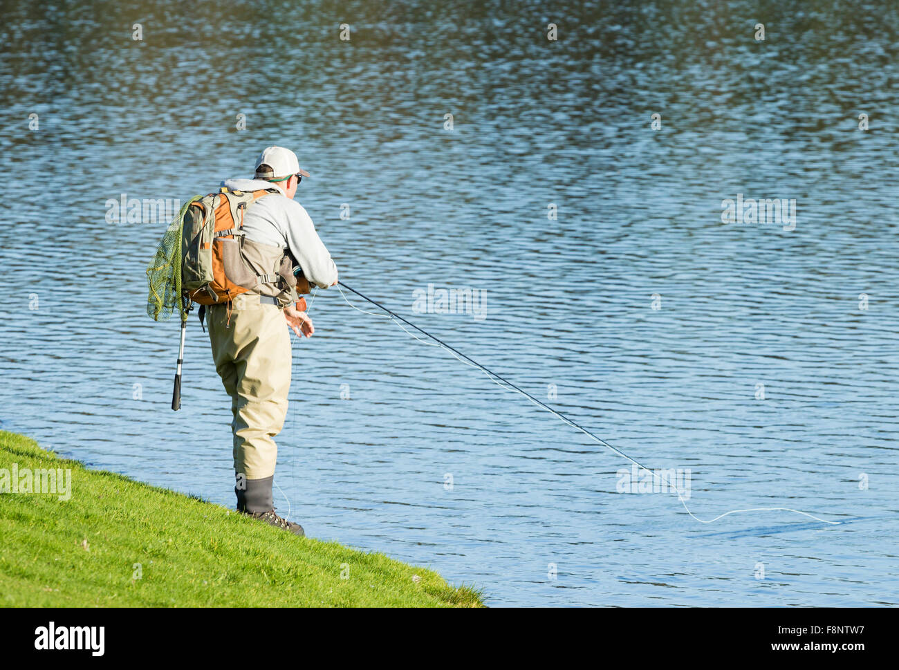 Man uses fishing rod to fish on the sea rocks in Cabo Frio, Rio de