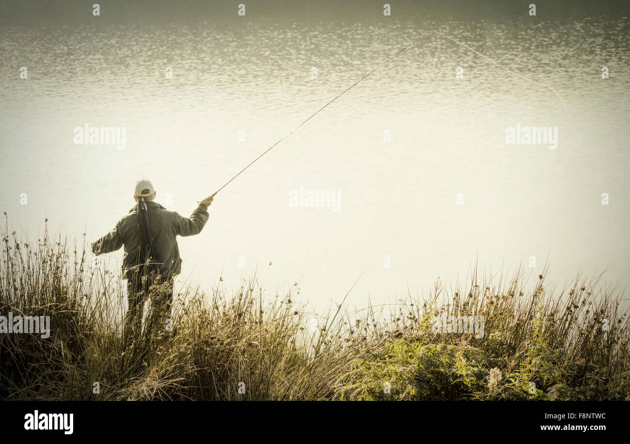 Man Fly fishing on reservoir Stock Photo
