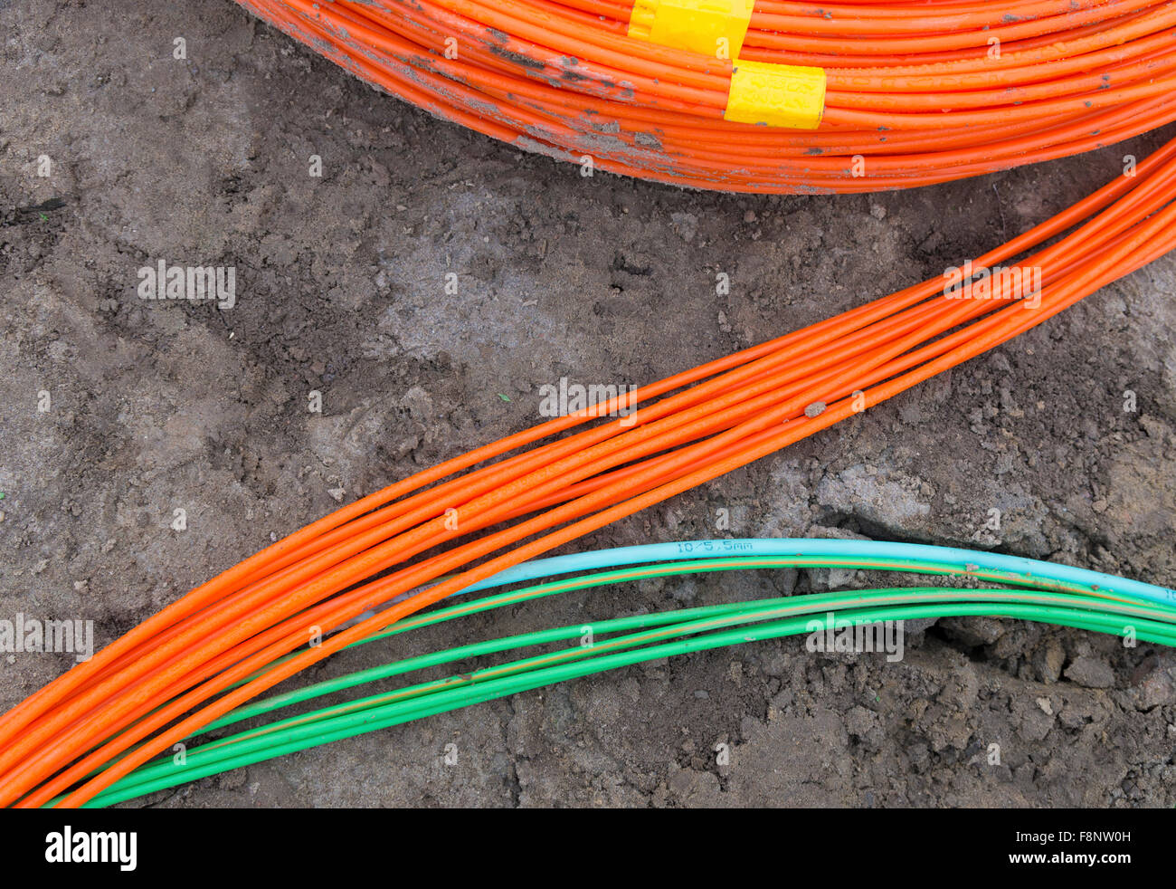 orange and green fiber optic cables on a construction site Stock Photo