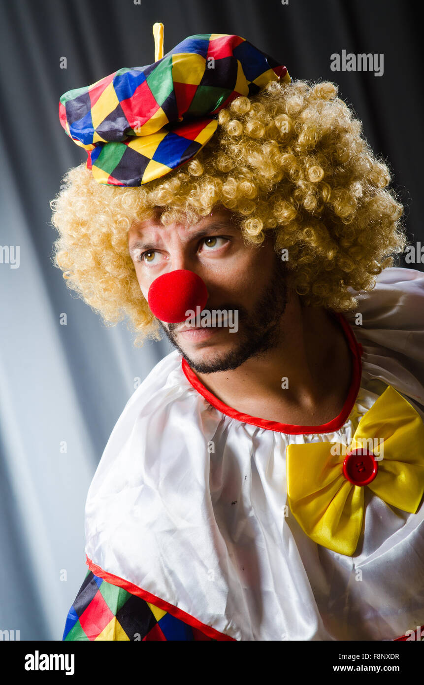 Funny clown in humorous concept against curtain Stock Photo - Alamy