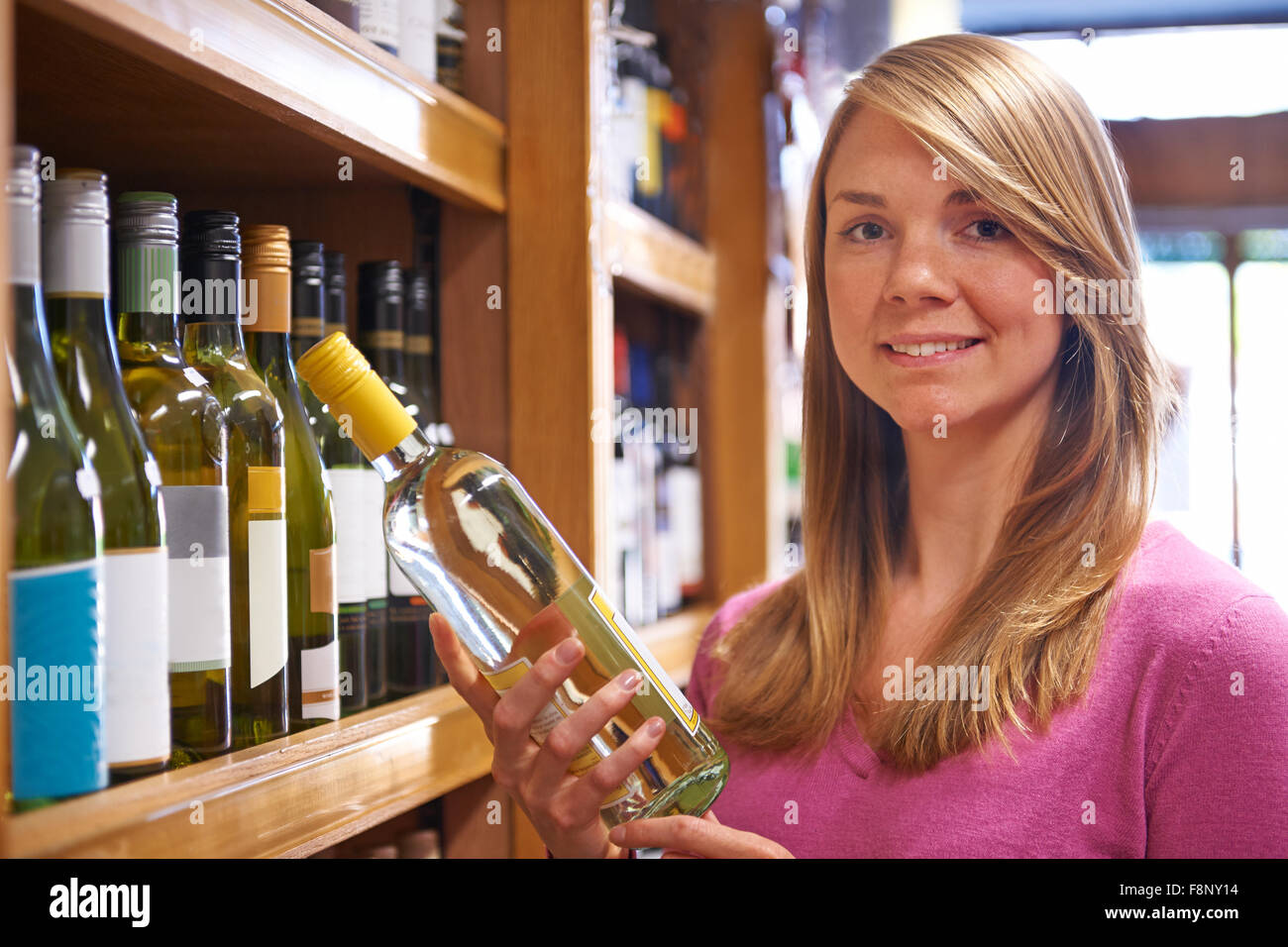 Woman Choosing Bottle Of White Wine In Supermarket Stock Photo Alamy