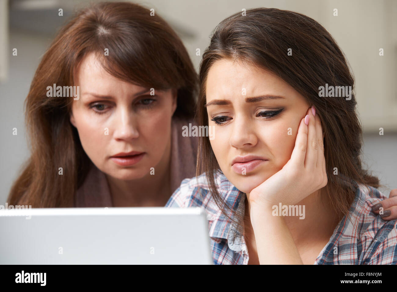 Mother Comforting Daughter Victimized By Online Bullying Stock Photo