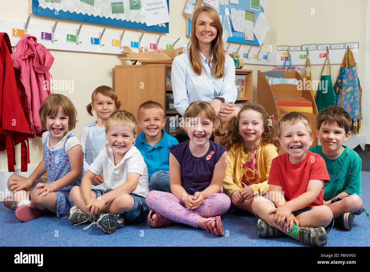 Elementary School Children With Teacher In Classroom Stock Photo