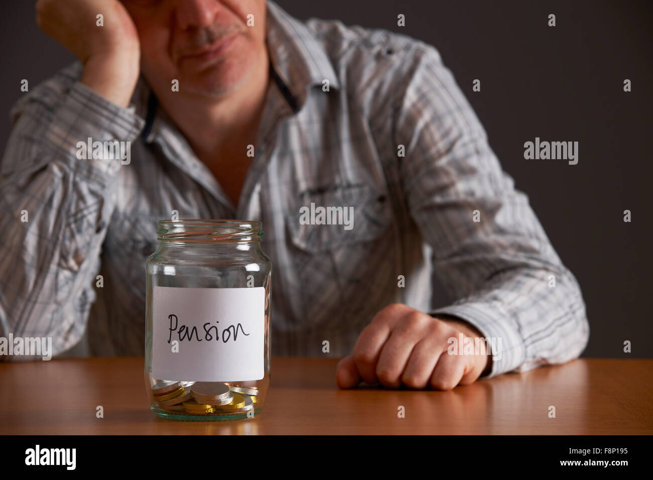 Depressed Man Looking At Empty Jar Labelled  Pension Stock Photo