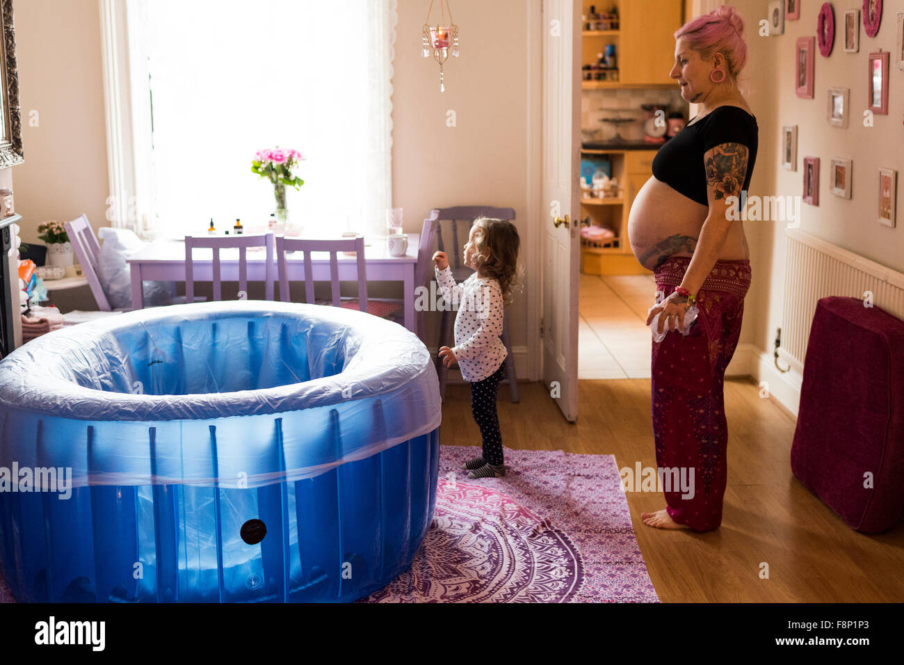 Pregnant Woman In Labour In Room With Birthpool And Child