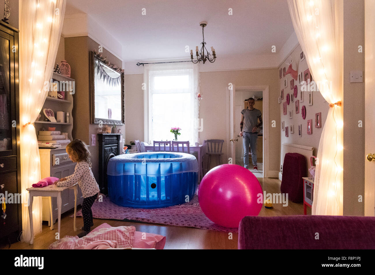 Living room set up with birthpool for a home birth with family present Stock Photo