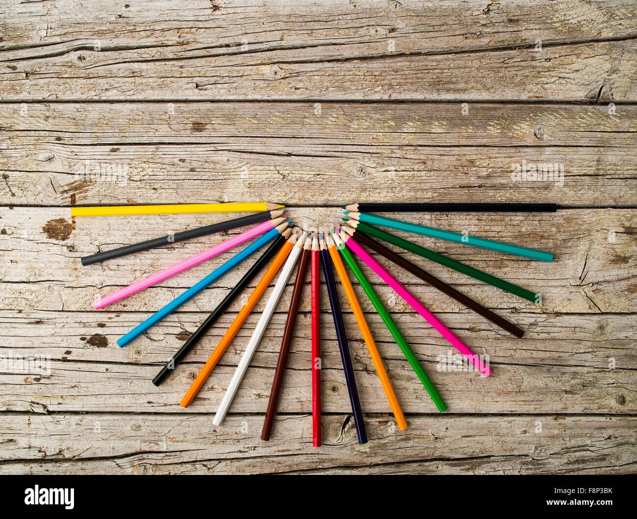 Colorful pencil crayons on wooden background Stock Photo