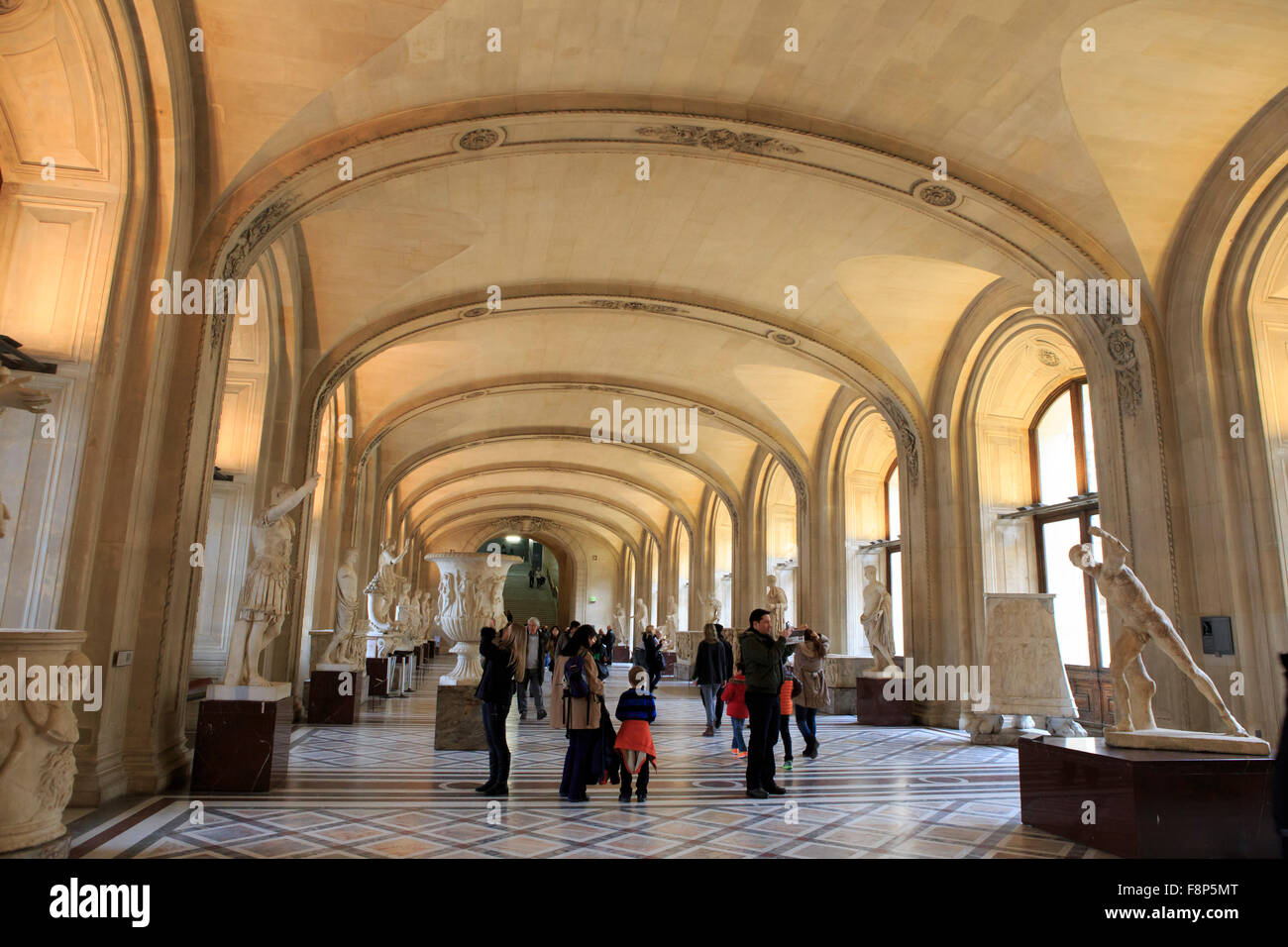 Visitors enjoy the Ancient Roman sculptures in The Louvre Museum, Paris