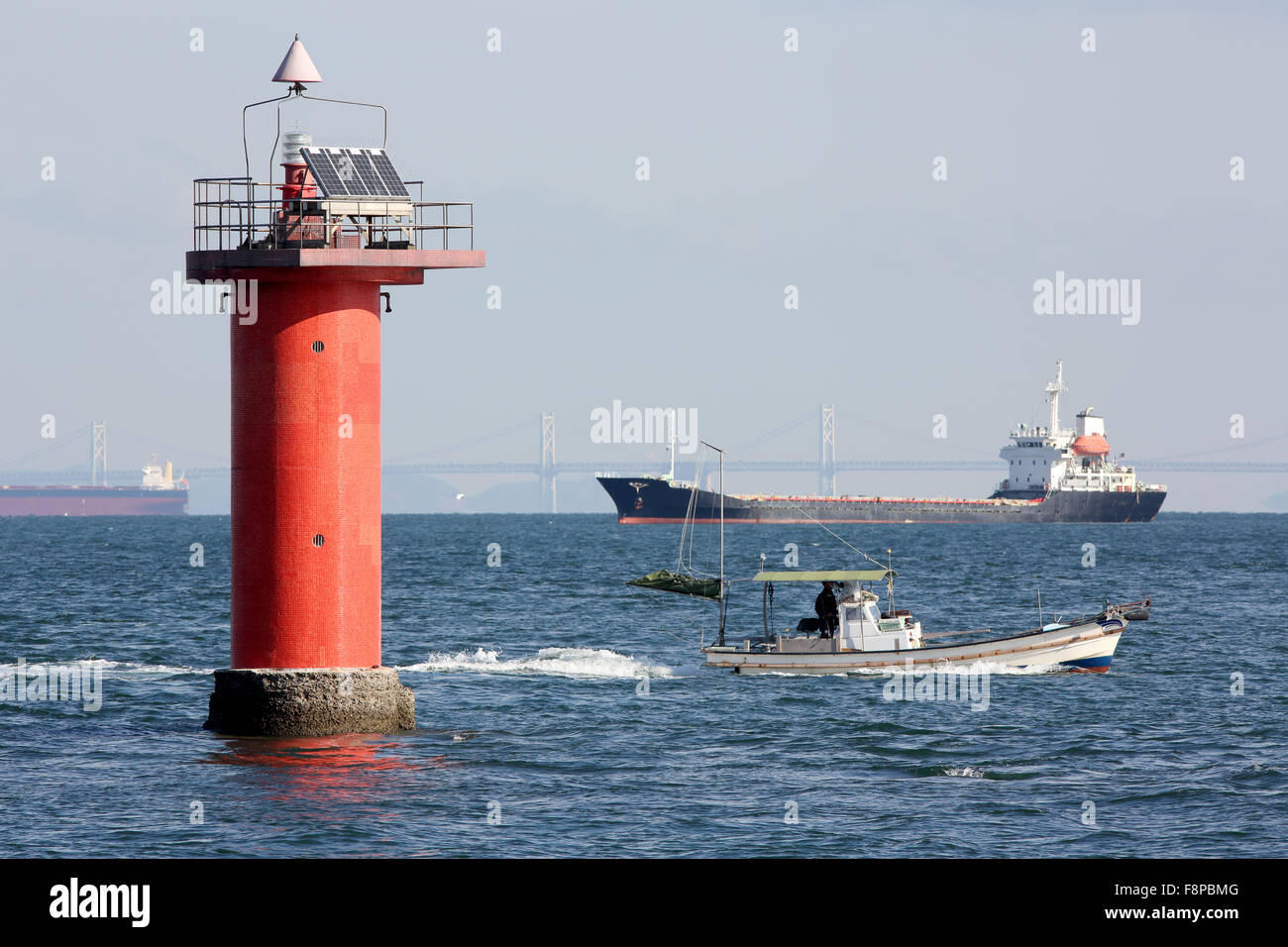 lighthouse with cargo ship in the sea Stock Photo Alamy