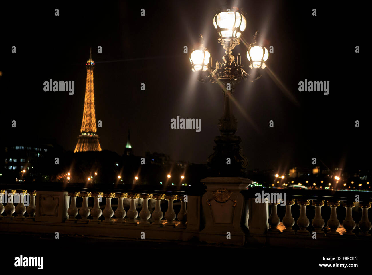 The Eiffel Tower lights up the night sky in Paris, France Stock Photo