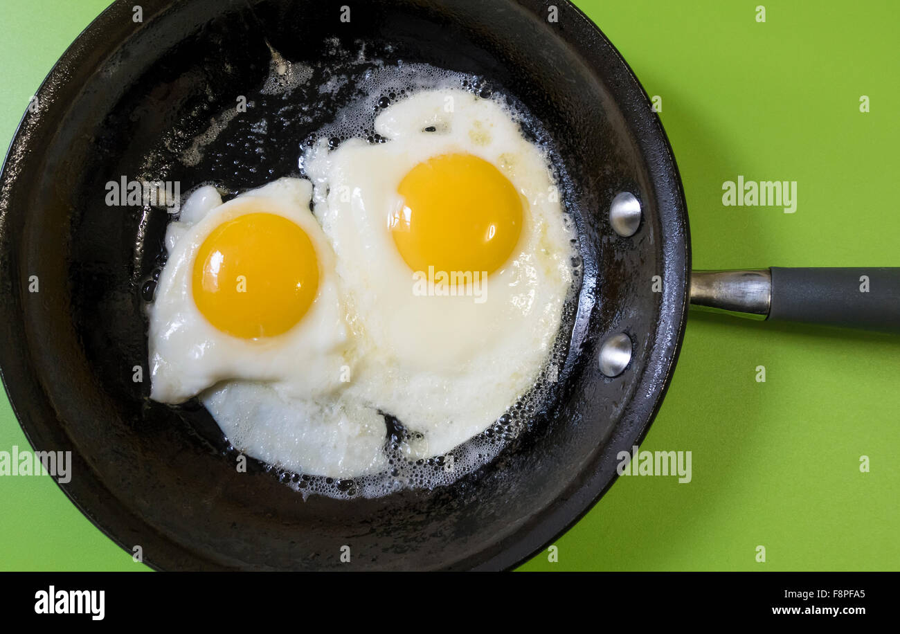 Fried eggs in a black metal pan Stock Photo