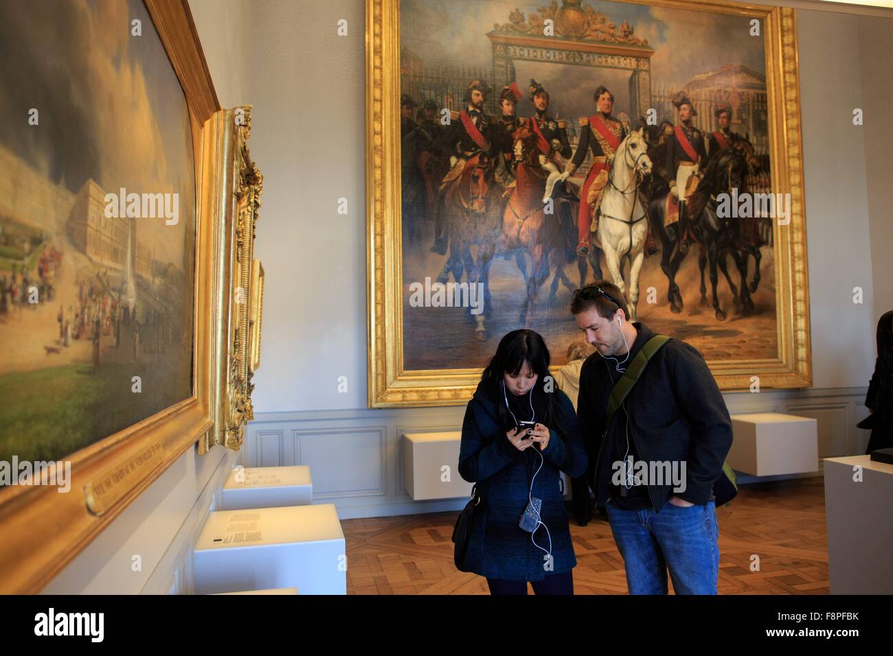 Watching a video on the audio guide provided at the Palace of Versailles, Paris, France Stock ...