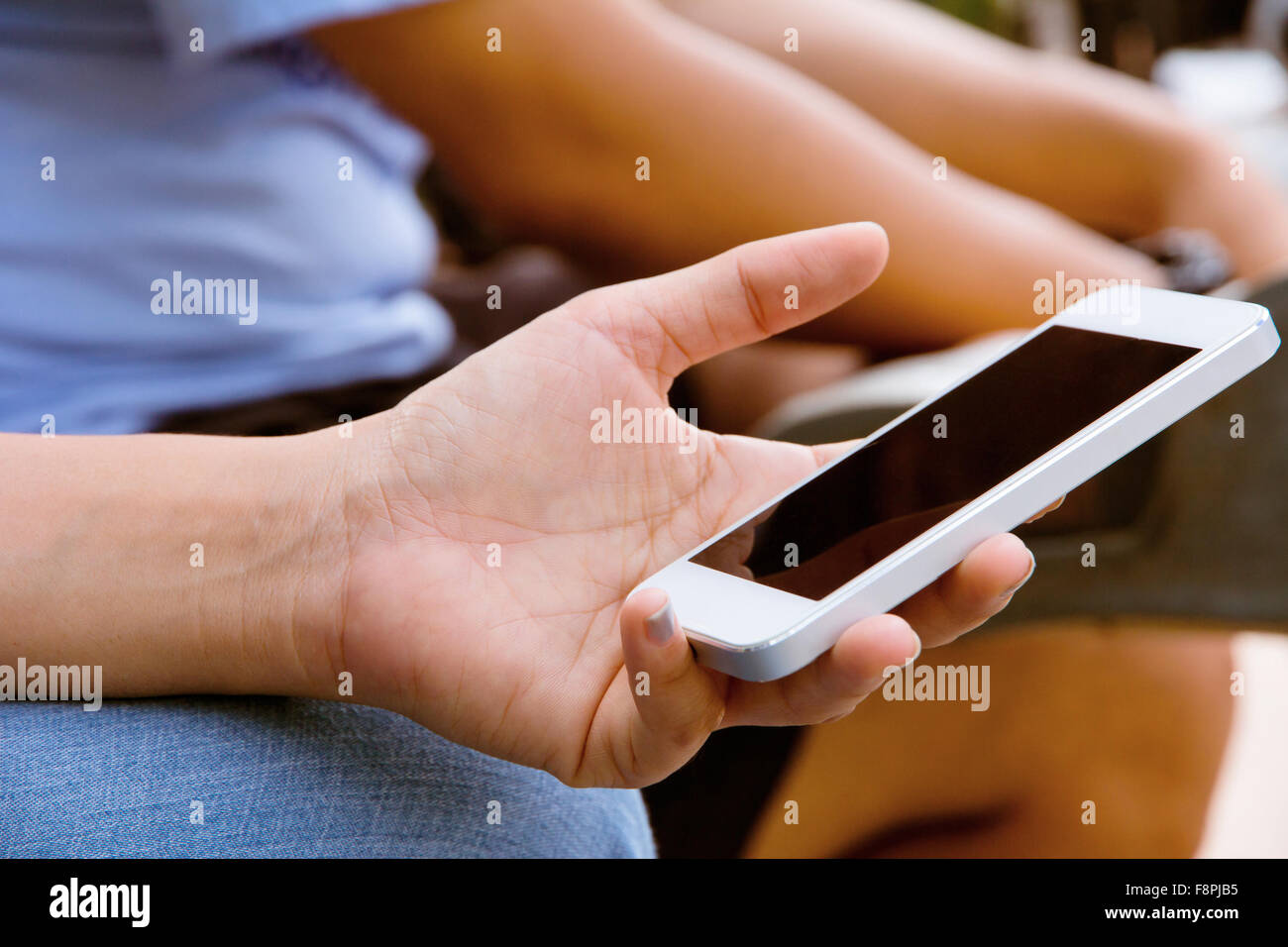 Image of people using a phone at a city Stock Photo - Alamy