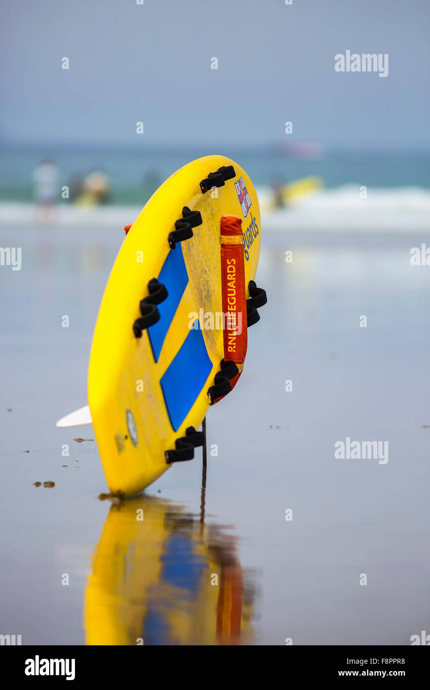 A lifeguard Rescue Board from the Royal National Lifeboat Institution on Polzeath beach, Cornwall UK Stock Photo