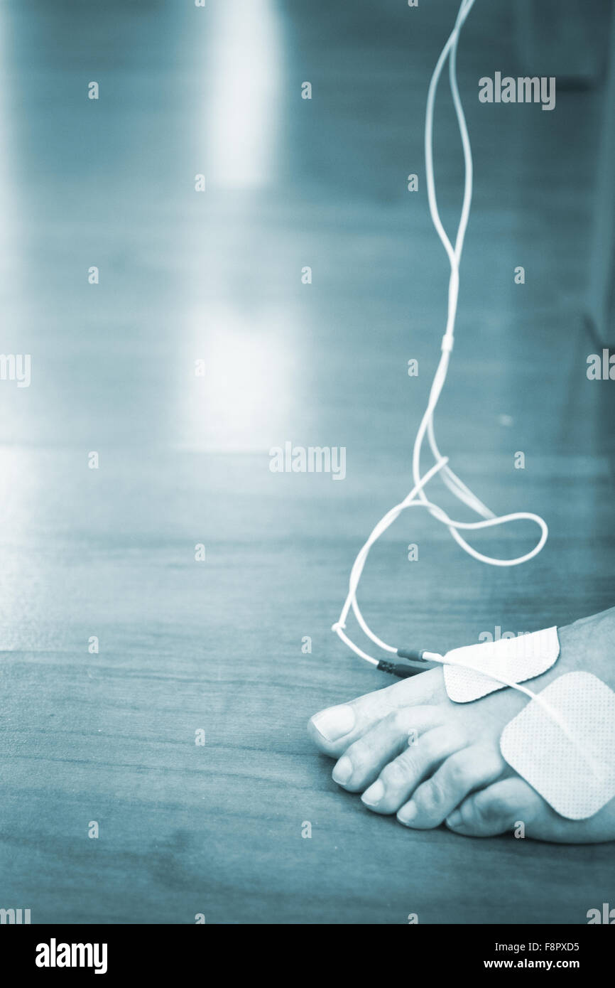 Patient foot, leg and ankle in electro physiotherapy electrical impulse