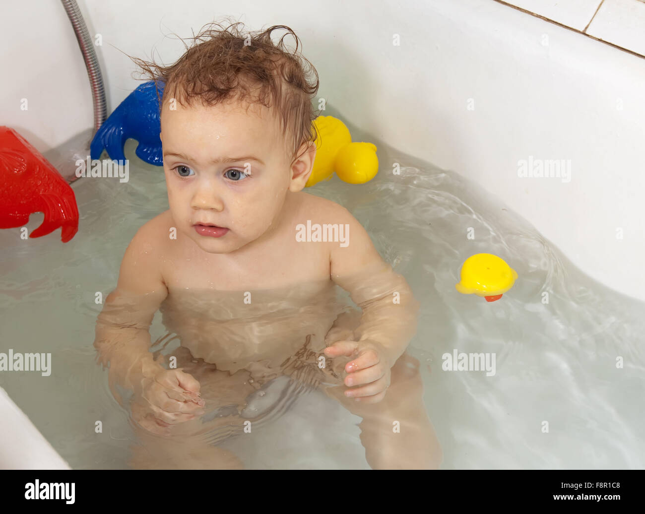 Toddler bathing with toys in bath Stock Photo Alamy