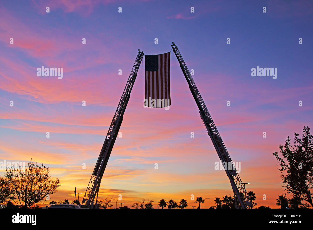 American flag between two fire engine ladder trucks at Christmas toy drive outside San Bernardino, California Stock Photo