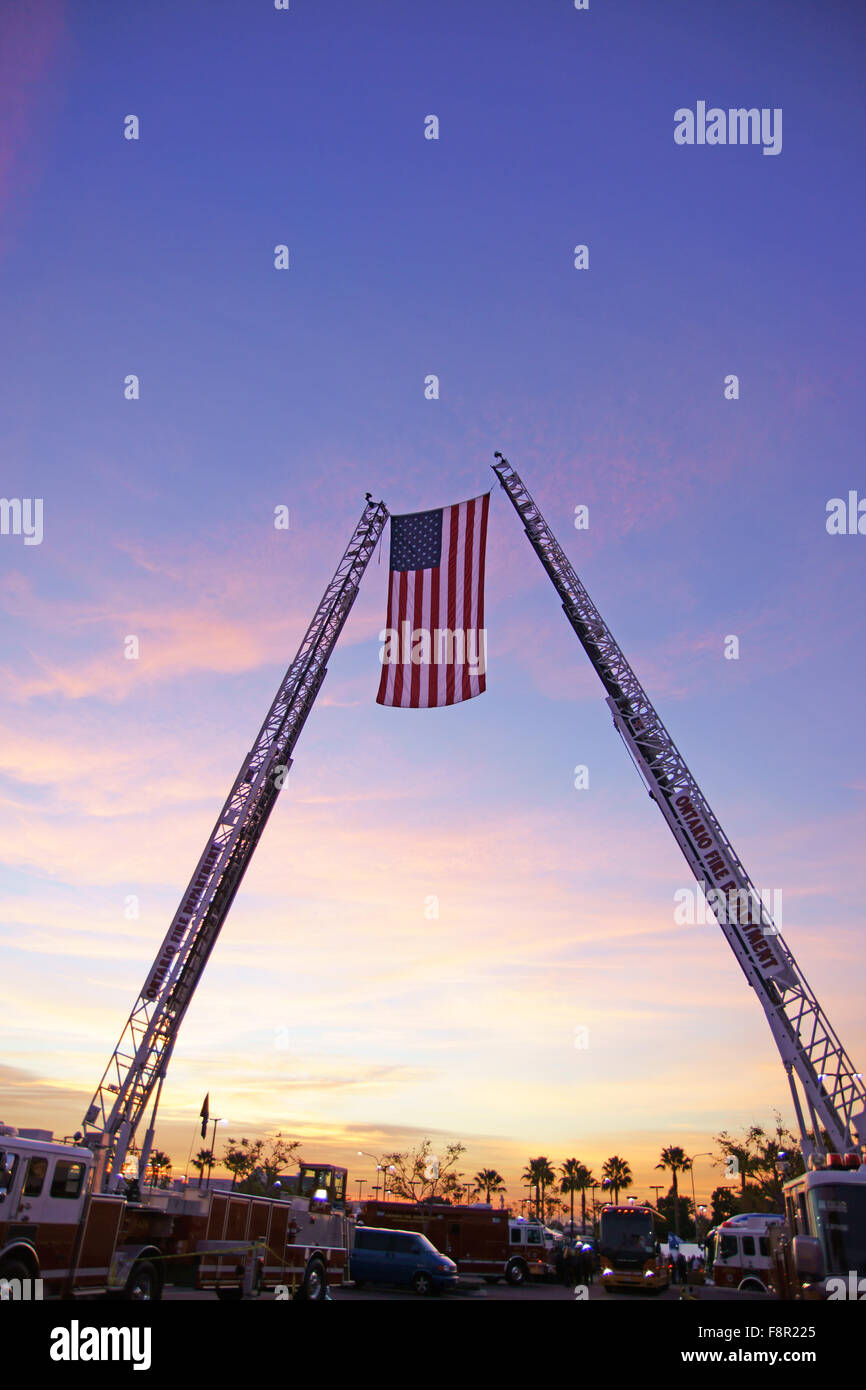 American flag between two fire engine ladder trucks at Christmas toy drive outside San Bernardino, California Stock Photo