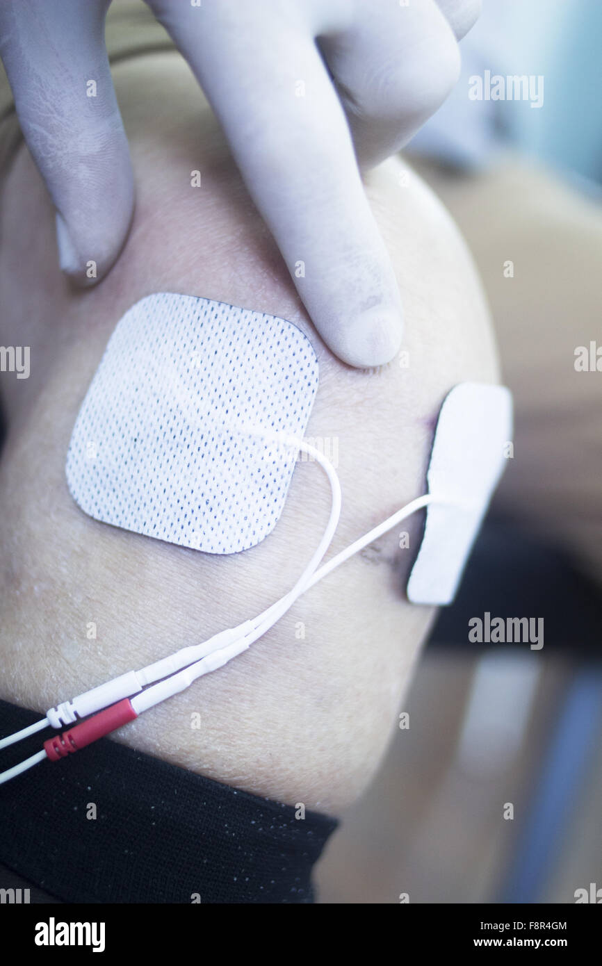 Patient leg and knee in electro physiotherapy electrical impulse