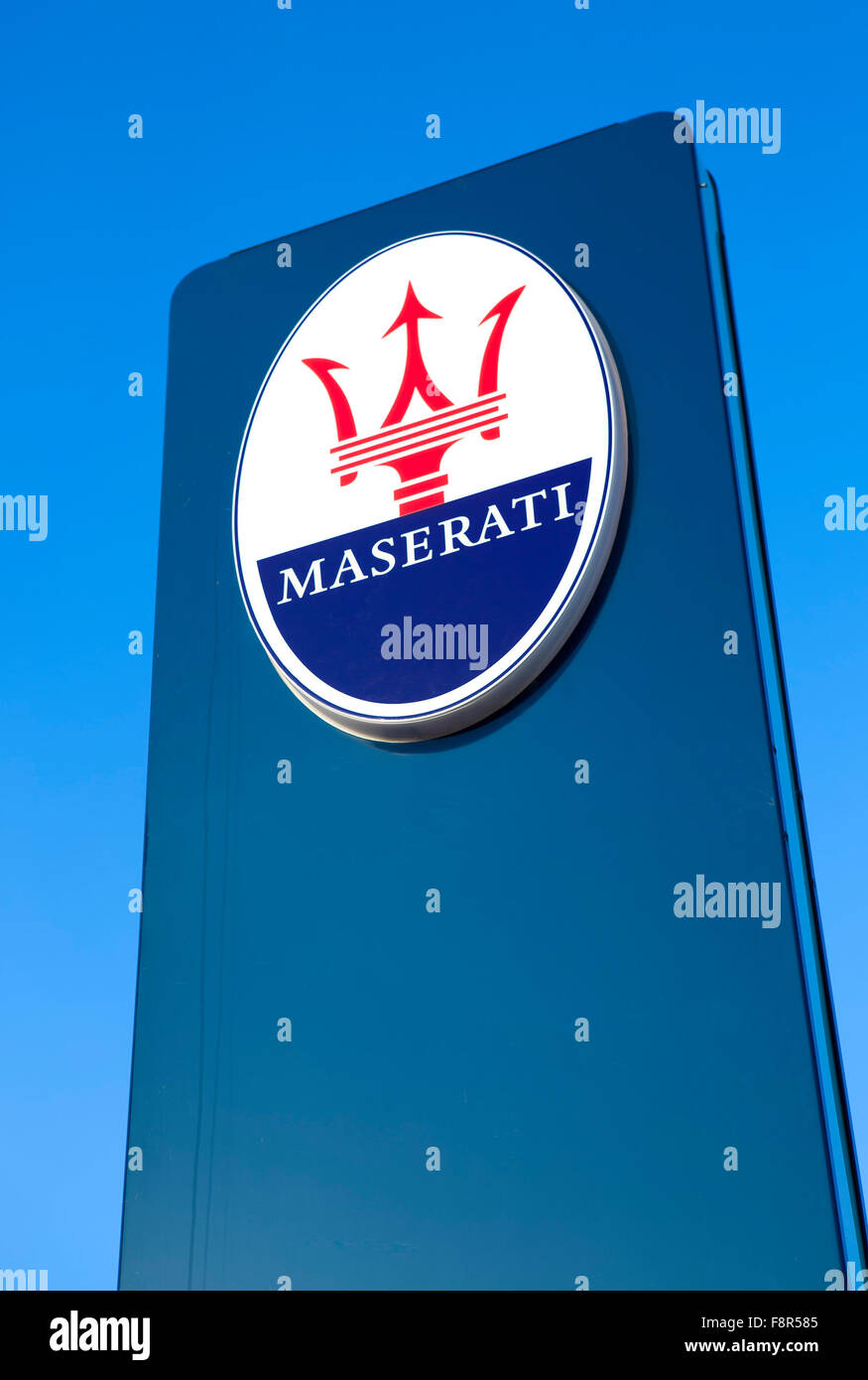 Maserati Sign Outside Car Dealership against a blue sky showing the