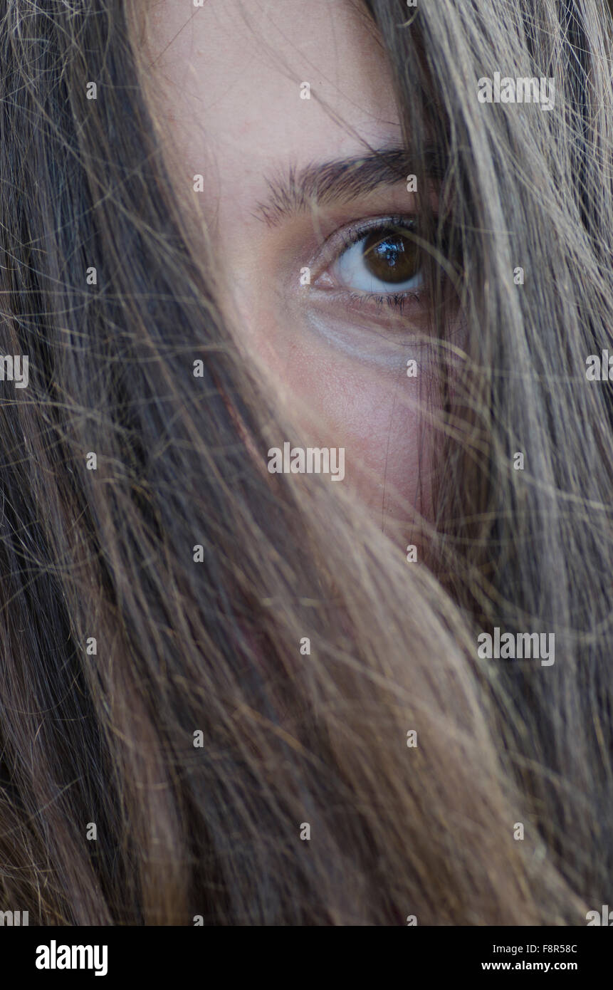 Sad teenage girl hair covering face outdoors Stock Photo