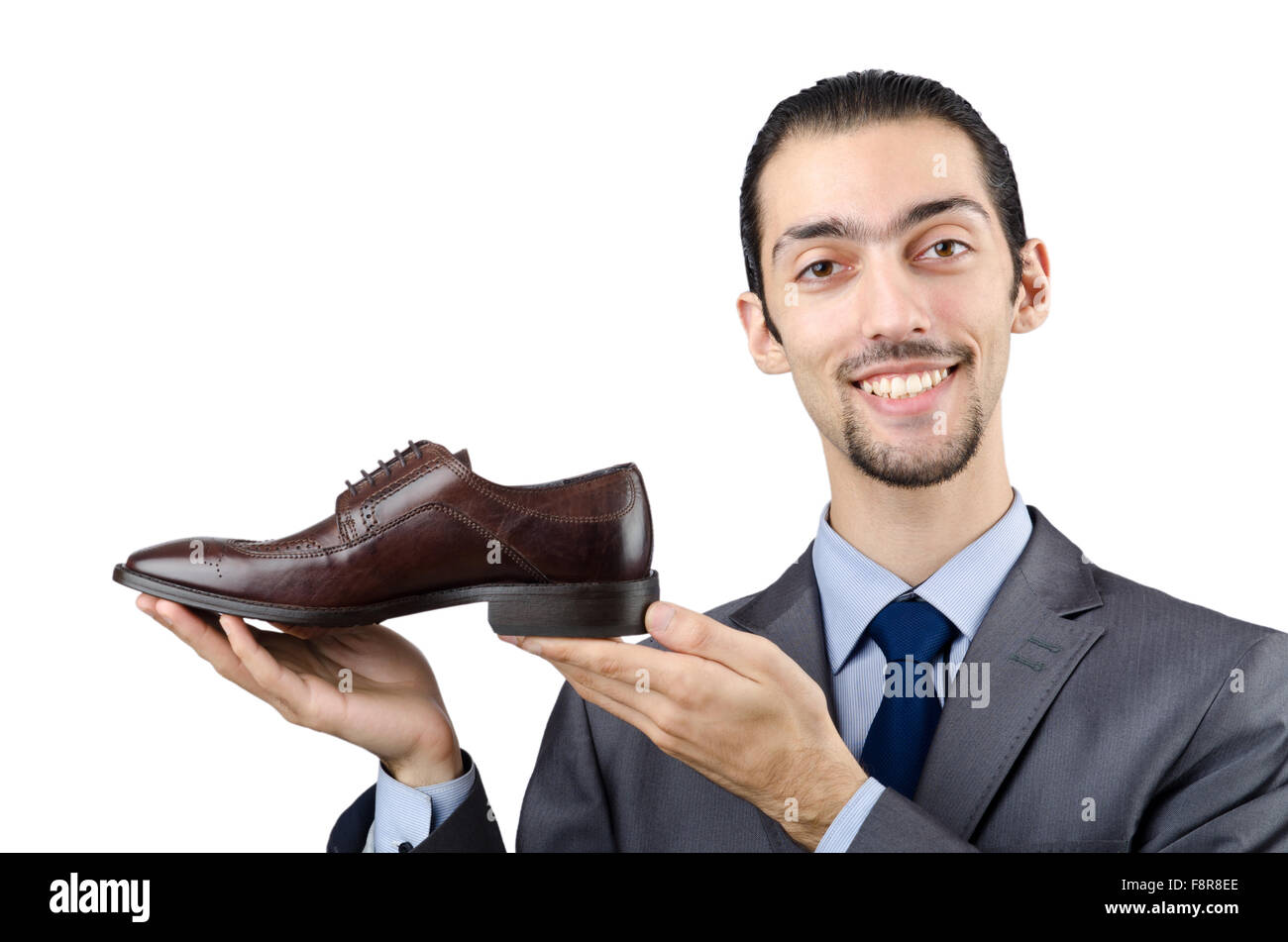 Около полутора часов пара туфель. Мужчина в туфлях на белом фоне. Мужчина держит обувь. Мужская рука держит туфлю. Обувь мужская держат в руках.