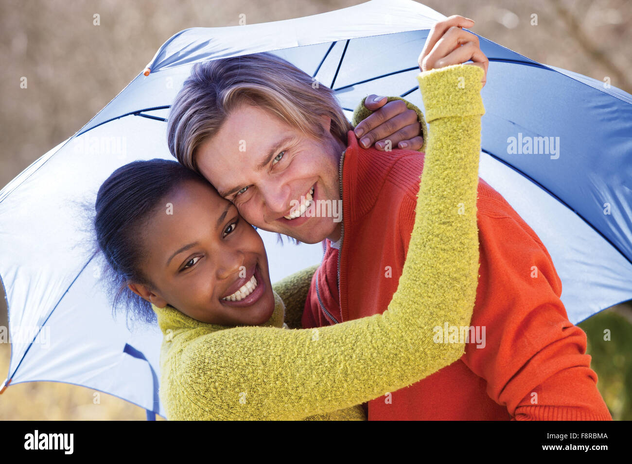 Young couple laughing in the rain under an umbrella Stock Photo - Alamy