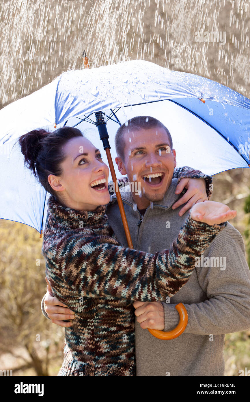 Young couple enjoying the rain under an umbrella Stock Photo - Alamy